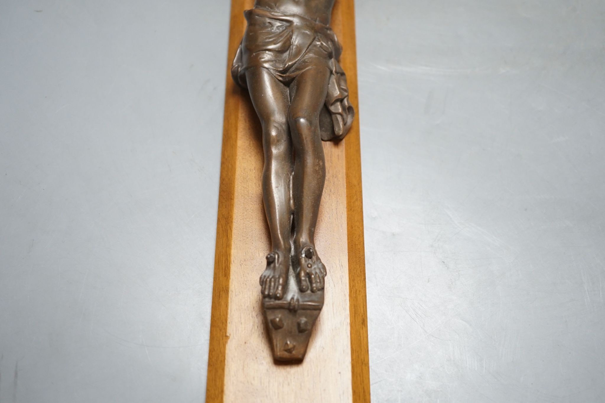 A bronze crucifix, mounted on a wooden cross, Height of cross, 60.5 cms.